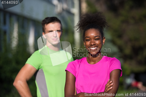 Image of portrait of young multietnic jogging couple ready to run