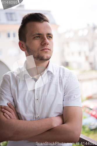 Image of man standing at balcony