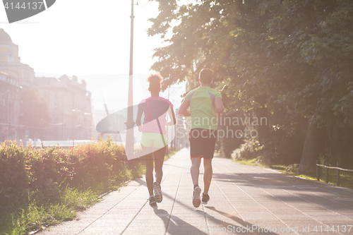 Image of young multiethnic couple jogging in the city