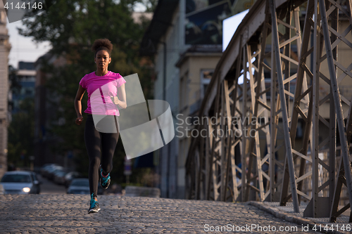 Image of african american woman running across the bridge