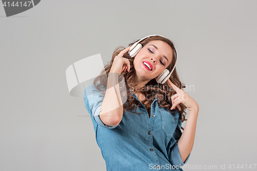 Image of Happy young woman listening music with headphones.