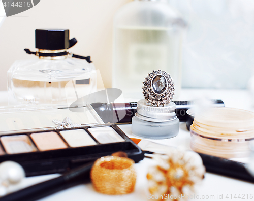 Image of Jewelry table with lot of girl stuff on it, little mess in cosme