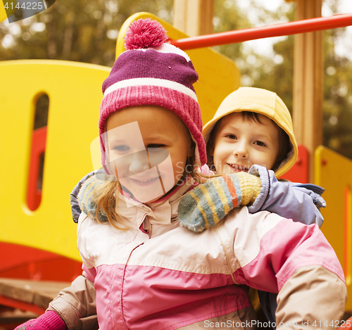 Image of little cute boy and girl playing outside on playground