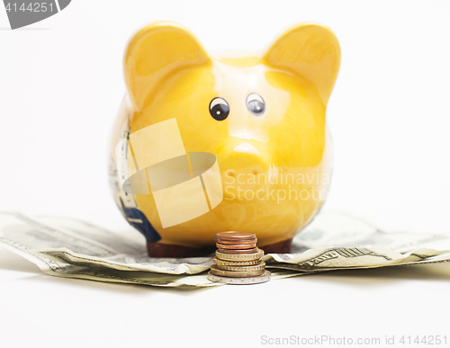 Image of Yellow piggy bank and Stack of money coins isolated over the white background lot dollar cash under it