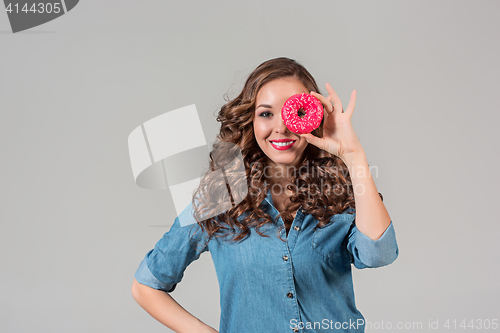 Image of The smiling girl on gray studio background with round cake