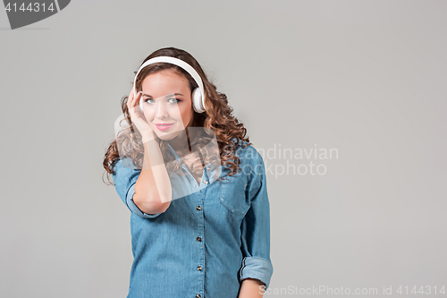 Image of Happy young woman listening music with headphones.