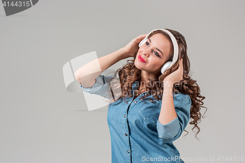 Image of Happy young woman listening music with headphones.