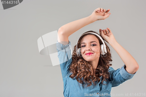Image of Happy young woman listening music with headphones.