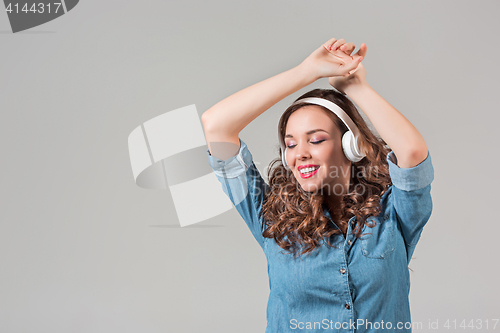 Image of Happy young woman listening music with headphones.