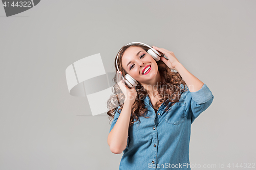 Image of Happy young woman listening music with headphones.