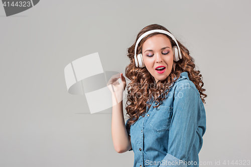 Image of Happy young woman listening music with headphones.
