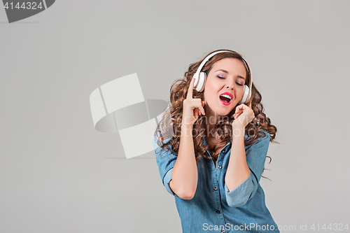 Image of Happy young woman listening music with headphones.