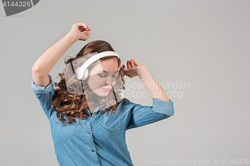 Image of Happy young woman listening music with headphones.