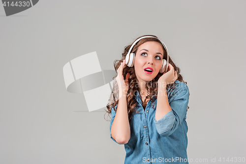 Image of Happy young woman listening music with headphones.