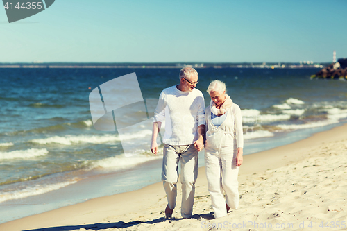 Image of happy senior couple holding hands on summer beach