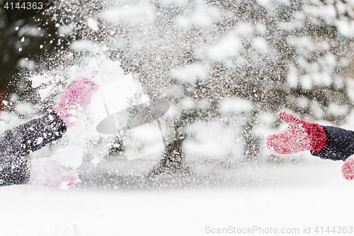 Image of happy friends playing with snow in winter