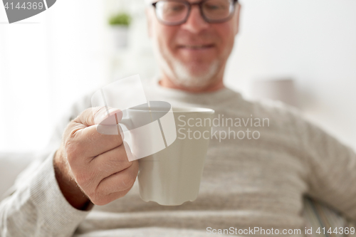 Image of happy senior man with cup of tea or coffee at home