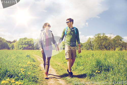 Image of happy couple with backpacks hiking outdoors