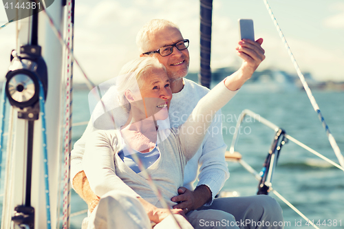 Image of senior couple taking selfie on sail boat or yacht