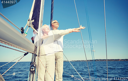 Image of senior couple enjoying freedom on sail boat in sea