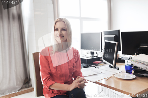 Image of happy creative female office worker with computers