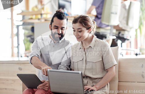 Image of creative team with tablet pc and laptop in office