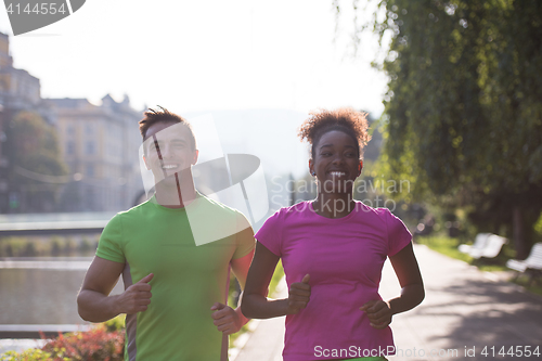 Image of young multiethnic couple jogging in the city