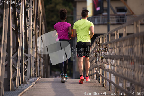 Image of multiethnic couple jogging in the city