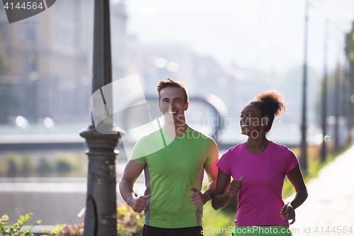 Image of young multiethnic couple jogging in the city