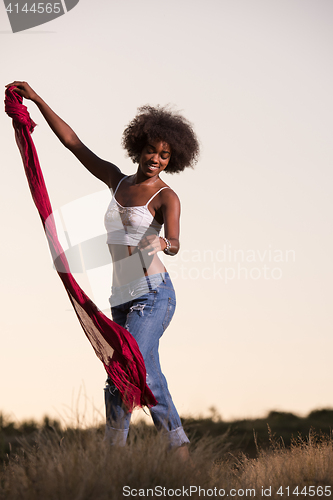 Image of black girl dances outdoors in a meadow