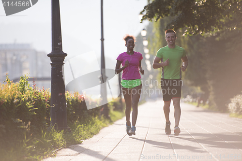 Image of young multiethnic couple jogging in the city