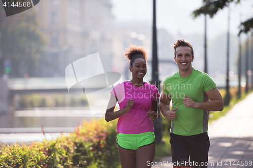 Image of young multiethnic couple jogging in the city