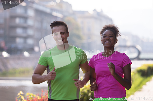 Image of young multiethnic couple jogging in the city