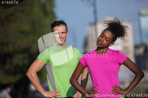 Image of portrait of young multietnic jogging couple ready to run