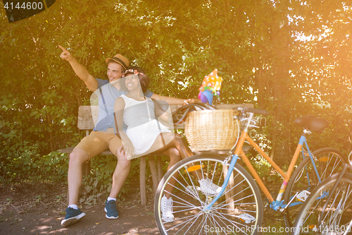 Image of Young multiethnic couple having a bike ride in nature