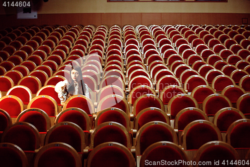 Image of portrait of a pretty girl hipster in a movie theater wearing hat, dreaming alone, lifestyle people concept