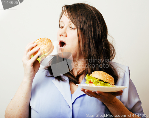 Image of fat white woman having choice between hamburger and salad close 