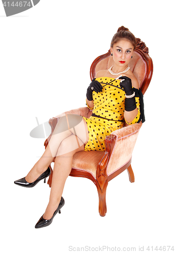 Image of Beautiful woman in armchair with a cigarette.