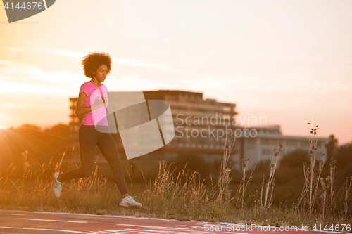 Image of a young African American woman jogging outdoors