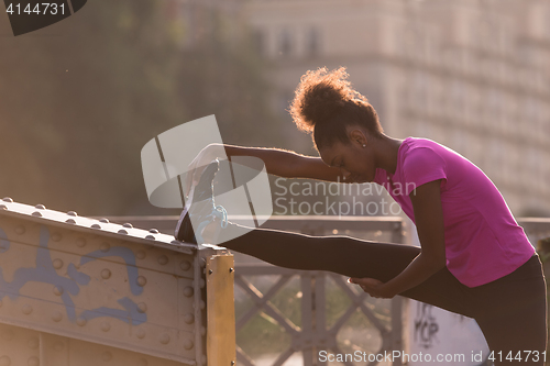 Image of African American woman doing warming up and stretching