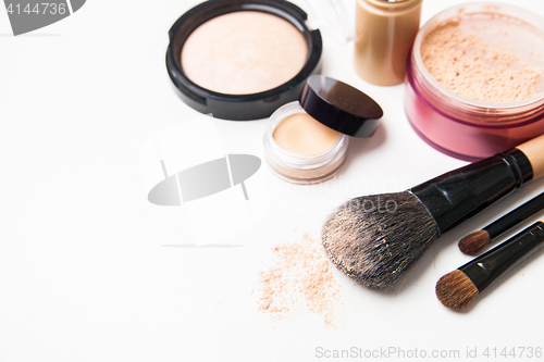 Image of Powder, foundation and brushes on the white background