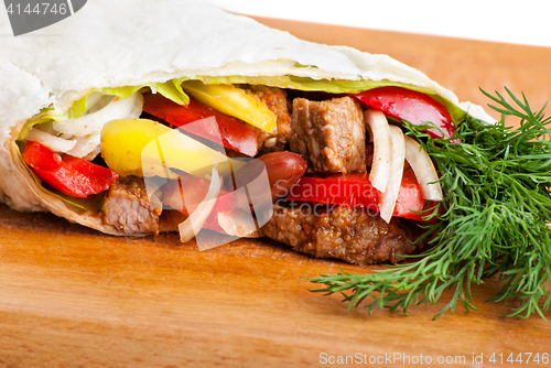 Image of beef burrito with peppers, onion and tomato