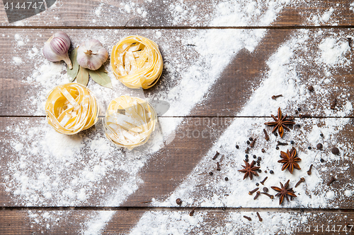 Image of Wooden rolling pin with flour and pasta