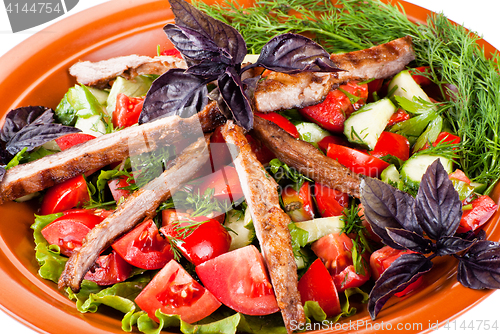 Image of Strips of roast beef and sauteed vegetables. Salad