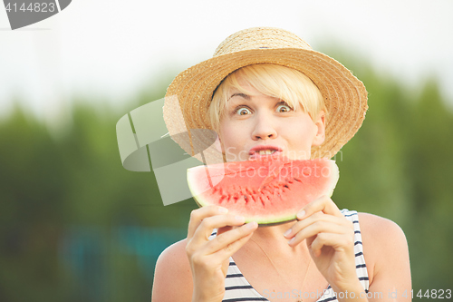 Image of Beautiful girl in straw hat eating fresh watermelon. Film camera style