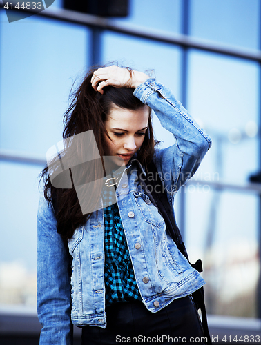 Image of young pretty girl near business building walking