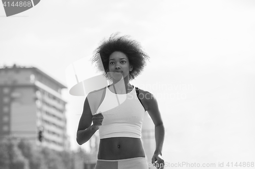 Image of Portrait of sporty young african american woman running outdoors