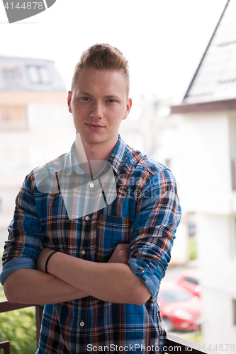 Image of man standing at balcony