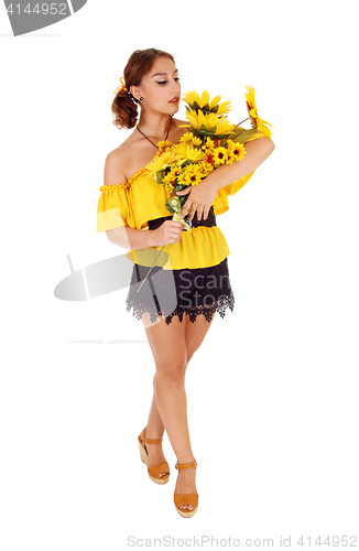 Image of Beautiful woman standing with sunflowers.