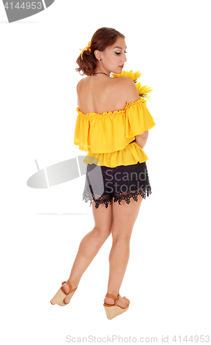 Image of Woman with sunflowers looking over shoulder.